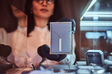 Yardımcısı özel altın kolye lüks mücevher deposunda gösterir.