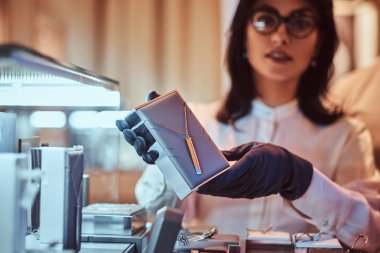 Yardımcısı özel altın kolye lüks mücevher deposunda gösterir.