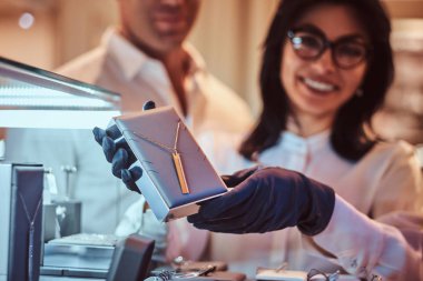 Yardımcısı özel altın kolye lüks mücevher deposunda gösterir.