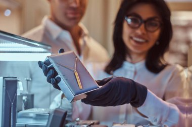 Yardımcısı özel altın kolye lüks mücevher deposunda gösterir.