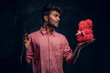 Pembe gömlekli bir Hintli adam güzel bir hediye tutar ve ona hevesli bir bakışla bakar. Romantik ruh hali, aşk ilişkisi.