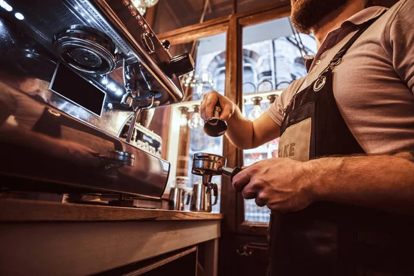 Low angle photo of a barista holding a portafilter, working in the coffee shop — Stock Photo, Image