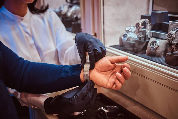 Donna assistente abiti esclusivi mens orologi presso i clienti mano nella gioielleria — Foto Stock