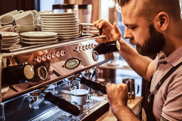 Foto de cerca de un elegante barista trabajando en una máquina de café en una cafetería —  Fotos de Stock