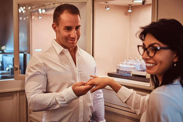 Elegantly dressed male makes wedding proposal his girlfriend in a luxury jewelry store