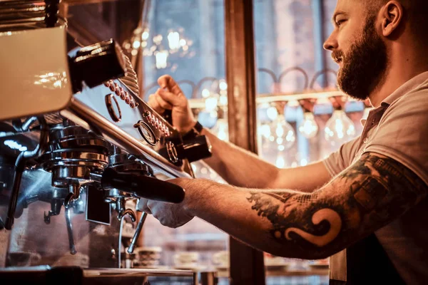 Barista en uniforme haciendo café para un cliente en la cafetería —  Fotos de Stock