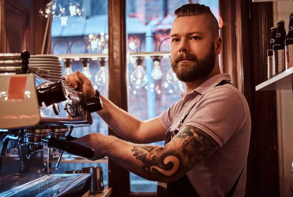 Dövmeli barista şık sakal ve saç modeli bir kafe ya da Restoran bir kahve makinesinde çalışma ile — Stok fotoğraf