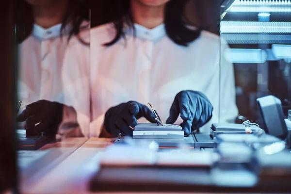 Assistant shows exclusive jewelry in a luxury shop — Stock Photo, Image