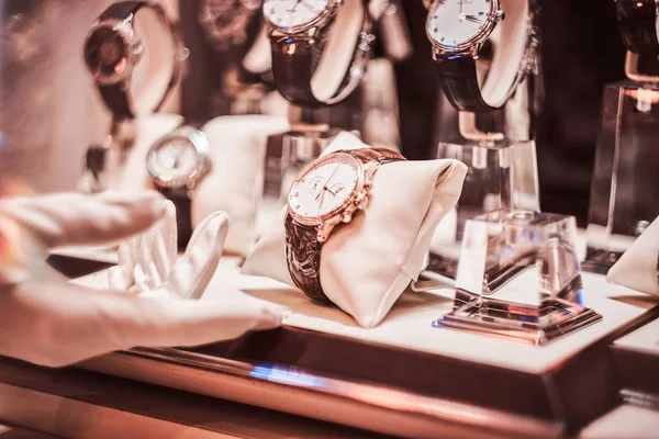 Крупним планом рукавички продавців показує ексклюзивний чоловічий годинник з нової колекції — стокове фото