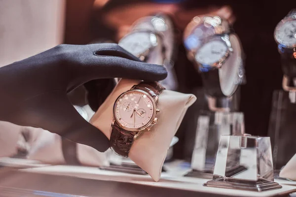 Gros plan de la main des vendeurs dans les gants montre la montre exclusive des hommes de la nouvelle collection — Photo