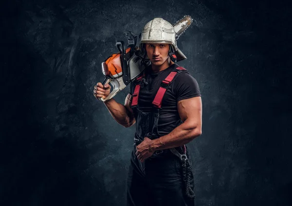Porträtt av en skogshuggare som bär skyddande kläder poserar med en motorsåg — Stockfoto