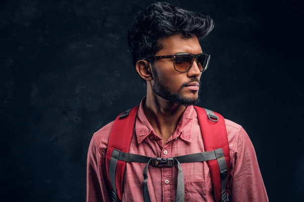 Caminhante elegante jovem com mochila usando óculos de sol olhando para os lados . — Fotografia de Stock