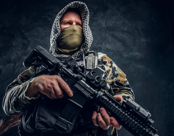 Forças especiais soldado de uniforme militar usando máscara e capuz segurando um rifle de assalto . — Fotografia de Stock