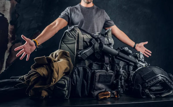 Случайно одетый мужчина показывает свою военную форму и снаряжение. Современное оборудование спецназа . — стоковое фото