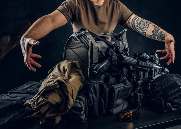 Casually dressed man showing his military uniform and equipment. Modern special forces equipment. — Stock Photo, Image