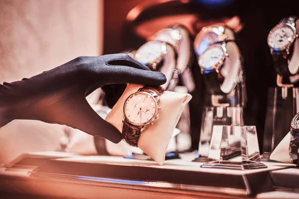 Close-up of the sellers hand in gloves shows the exclusive mens watch from the new collection — Stock Photo, Image