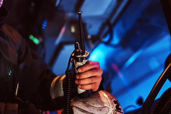 Brandweerman in een beschermende uniform in de brandweerauto zitten en houden walkie-talkie. Hand close-up. — Stockfoto