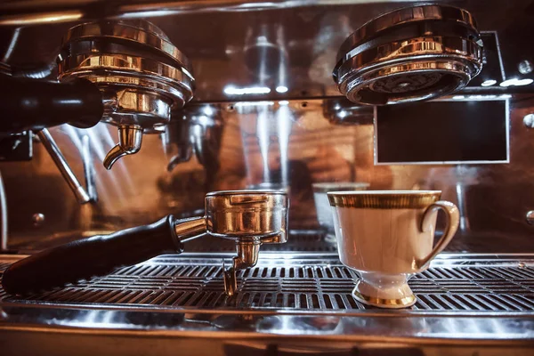 Zbliżenie: ubijaka i kubek z cappuccino obok ekspres do kawy w restauracji coffee shop — Zdjęcie stockowe