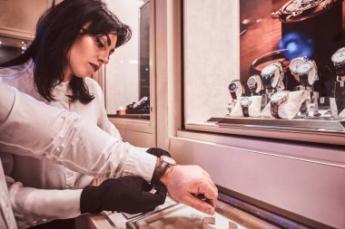 Satıcı özel erkek saatler lüks mücevher mağazasında denemek için istemci yardımcı olur.