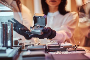 Kadın Yardımcısı özel altın yüzük takı mağaza gösterir.