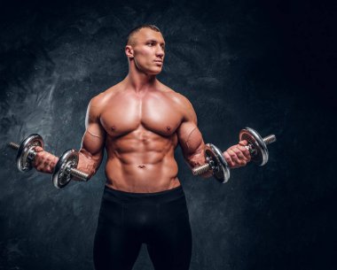 İki dambıl trenlerle kas genç adam.