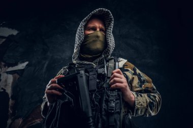Özel Kuvvetler asker askeri üniformalı maskesi ve bir saldırı tüfeği tutan başlık giyiyor.