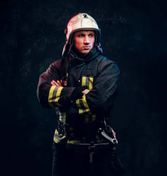 Manly firefighter in helmet looks sideways