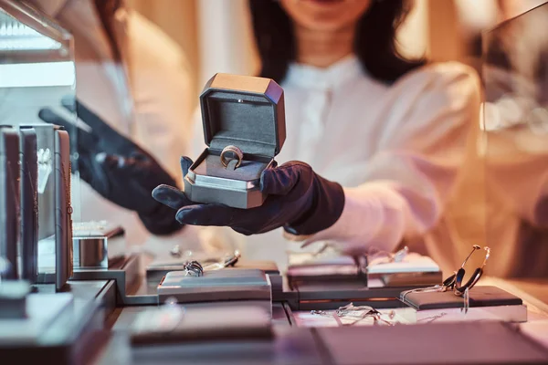 Assistante femme montre la bague en or exclusif dans la bijouterie — Photo