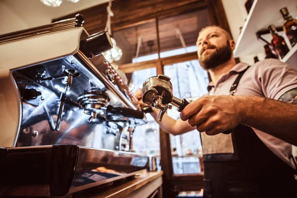 Low angle photo of a barista holding a portafilter, working in the coffee shop — Stock Photo, Image