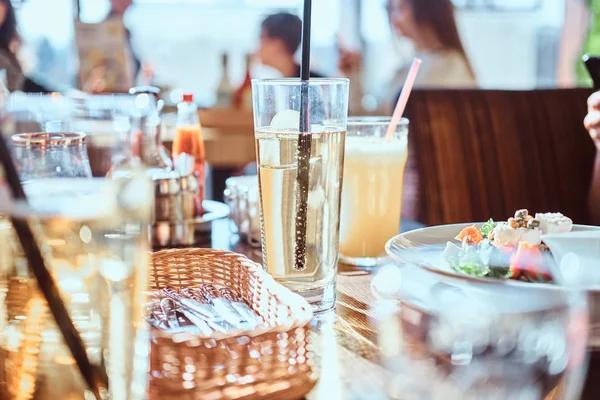 Los amigos cenan en el café al aire libre. Imagen de cerca de una mesa con diferentes platos y bebidas — Foto de Stock
