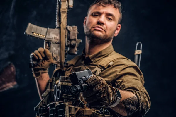 Special forces soldier wearing body armor holding assault rifle and aiming a gun at the camera. — Stock Photo, Image