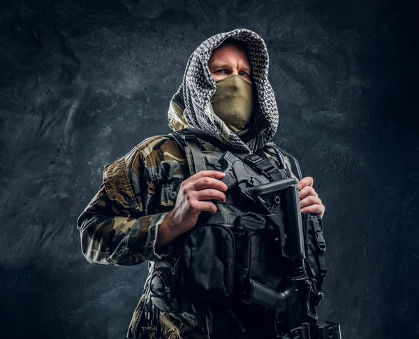 Forças especiais soldado de uniforme militar usando máscara e capuz segurando um rifle de assalto . — Fotografia de Stock