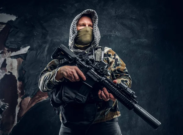 Forças especiais soldado de uniforme militar usando máscara e capuz segurando um rifle de assalto . — Fotografia de Stock