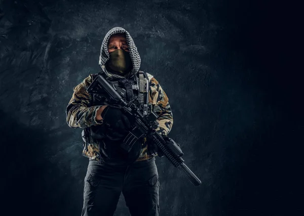 Forças especiais soldado de uniforme militar usando máscara e capuz segurando um rifle de assalto . — Fotografia de Stock