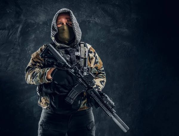 Forças especiais soldado de uniforme militar usando máscara e capuz segurando um rifle de assalto . — Fotografia de Stock