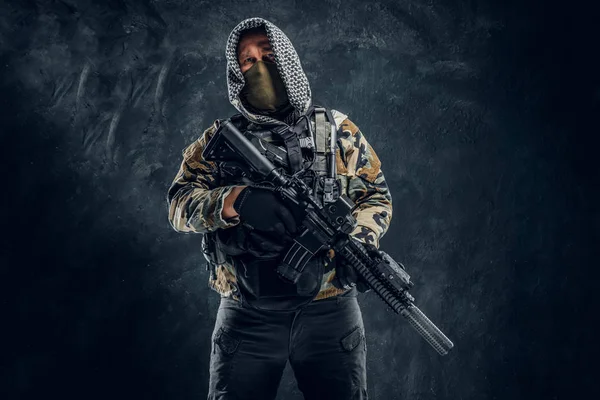 Forças especiais soldado de uniforme militar usando máscara e capuz segurando um rifle de assalto . — Fotografia de Stock