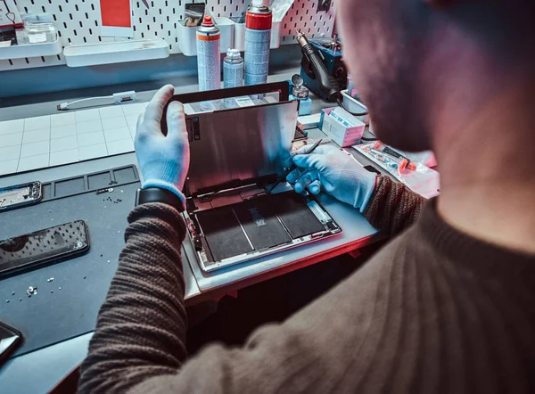 Le technicien répare une tablette cassée dans un atelier de réparation — Photo