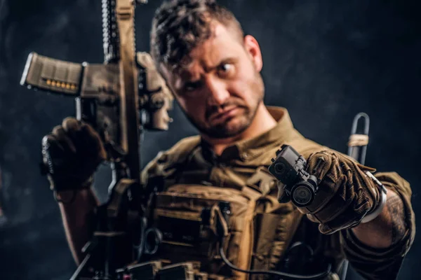 Special forces soldier wearing body armor holding assault rifle and aiming a gun at the camera. — Stock Photo, Image