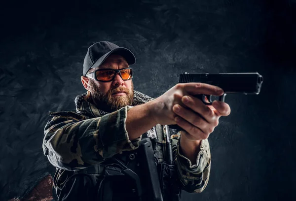 Uomo brutale in uniforme militare camuffato con una pistola in mano e mirando al nemico . — Foto Stock