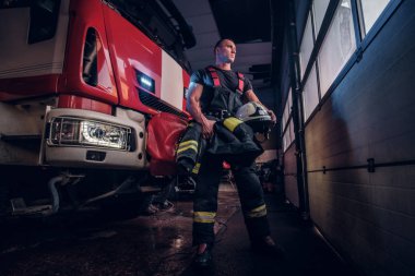 Kas itfaiyeci koruyucu bir kask bir itfaiye garajda holding