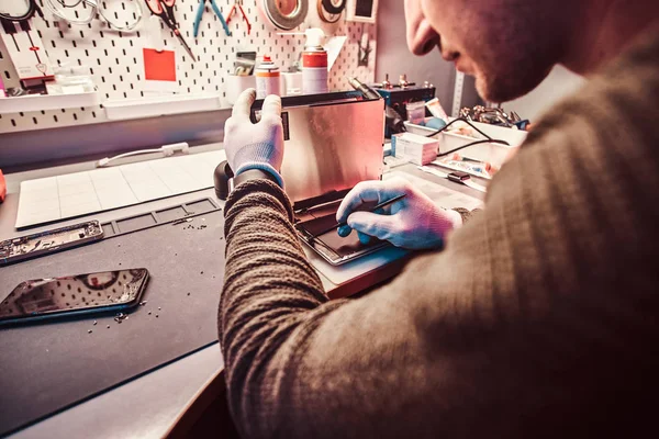 O técnico repara um computador tablet quebrado em uma oficina de reparo — Fotografia de Stock