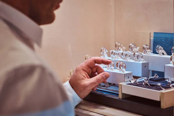 Hombre eligiendo un anillo de bodas en joyería de lujo —  Fotos de Stock