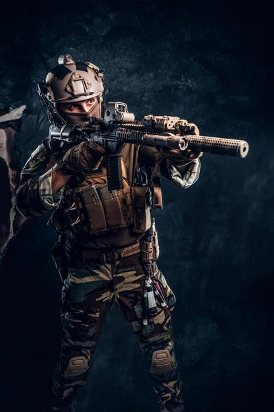 Elitstyrka, specialstyrkor soldat i kamouflage uniform håller en automatkarbin med en lasersikte och mål vid målet. — Stockfoto