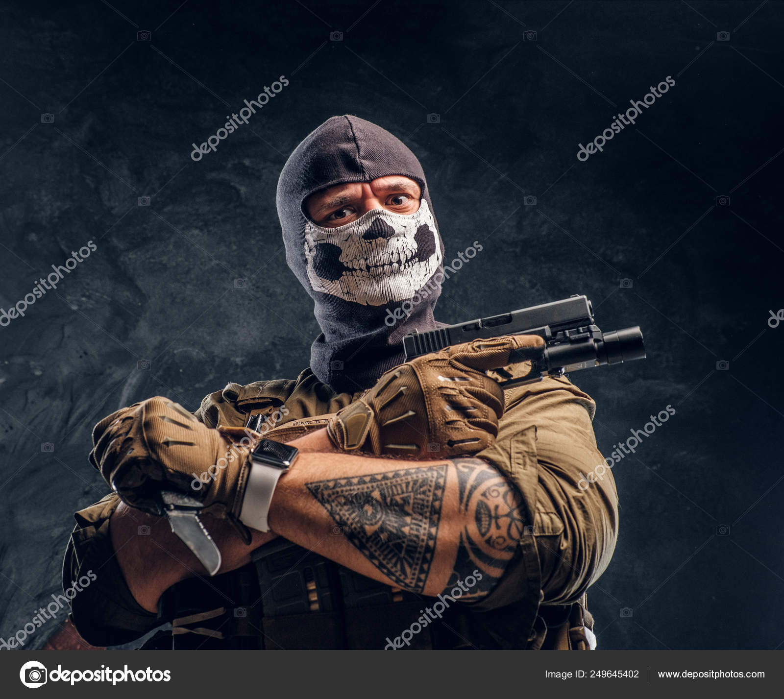 Un terroriste en uniforme militaire et un crâne de cagoule tenant