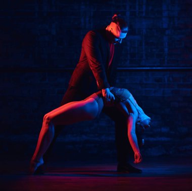 Güzel çift bir gece kulübünde dans pistinde dans. Karanlıkta aydınlatma ile gerçekleştirme dansçılar