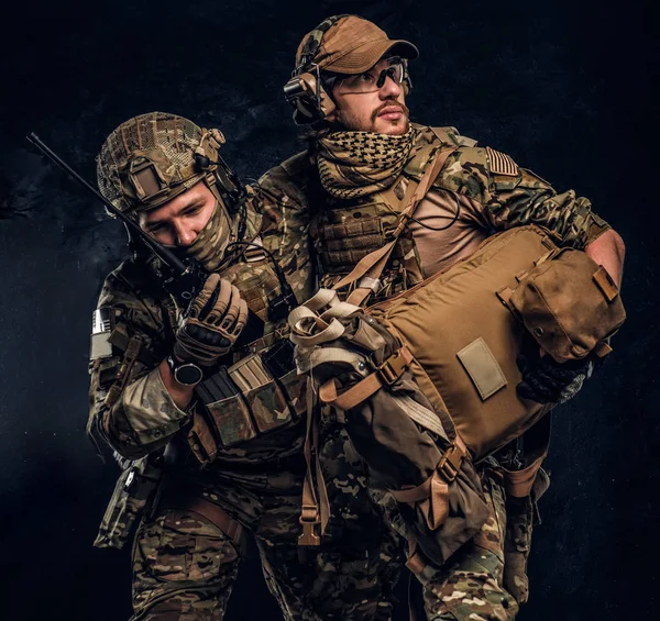 Conflicto de combate, misión especial, retirada. Médico militar rescata a su compañero herido llevándolo fuera del campo de batalla . —  Fotos de Stock