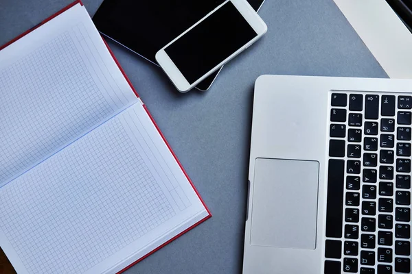 Laptop, tablet, smartphone e notebook em uma mesa no escritório — Fotografia de Stock