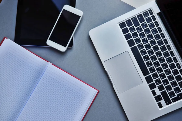 Laptop, tablet, smartphone e notebook em uma mesa no escritório — Fotografia de Stock