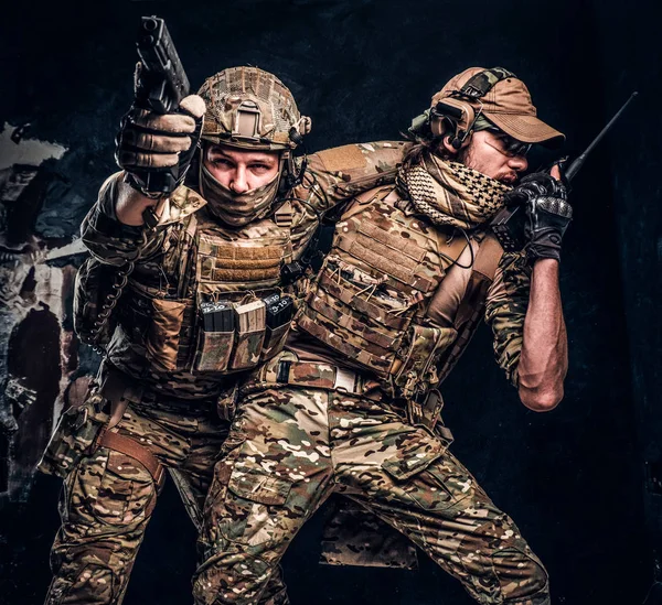 Kampfkonflikte, besondere Mission. der Soldat, der Teamkollegen aus dem Schlachtfeld trägt. Studiofoto vor dunkler Wand — Stockfoto