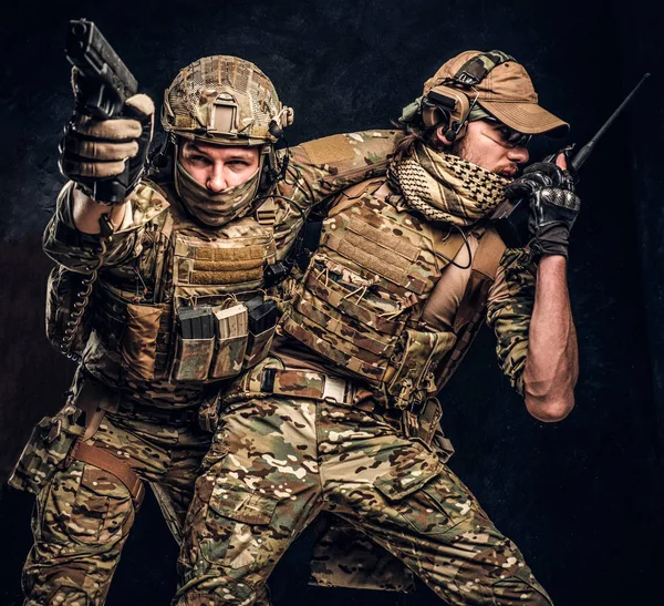 Combat conflict, special mission. The military soldier carrying teammate out of the battlefield. Studio photo against a dark wall — Stock Photo, Image
